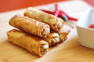 Spring rolls with chili sauce on the wooden background photo