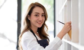 Retrato de mujer joven asiática SM trabajando con una caja en casa el lugar de trabajo.Propietario de una pequeña empresa de inicio, pequeña empresa emprendedora o empresa independiente en línea y concepto de entrega. foto