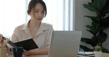 joven empresaria asiática trabaja en tableta con computadora portátil en la oficina. foto