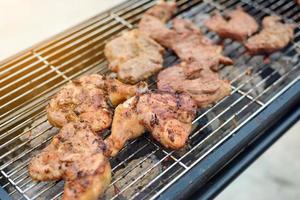 Grilled chicken thigh on the charcoal stove photo