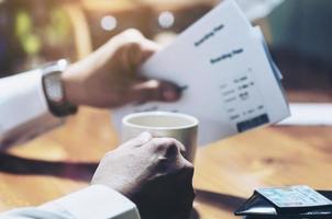 Man holding coffee cup and boarding pass waiting for flight travel by airplane for business work photo