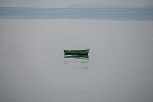 un pequeño barco de pesca está anclado. dejar de pescar cerca de la costa foto