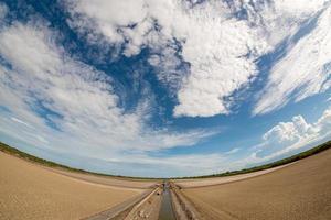 The dry land, the afternoon vulture and the bright sky There are many types of white clouds covered. photo