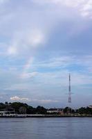 arco iris en el río chao phraya con torres de señales foto