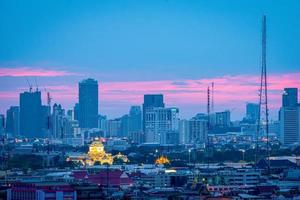 edificio de oficinas de gran altura en el centro de la ciudad de bangkok. al amanecer, la luz del cielo es azul y naranja. foto