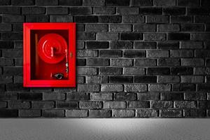 fire extinguish equipment with black brick wall photo