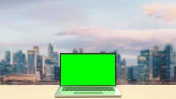 The notebook display green screen on rooftop building  for present concept 3d rendering photo