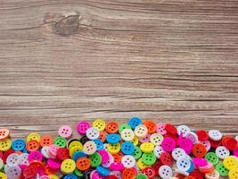 Buttons multi color on wood table for diy or handcrafted  concept. photo