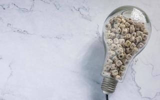 light bulb and alphabet wood cube on white marble for idea or think concept photo