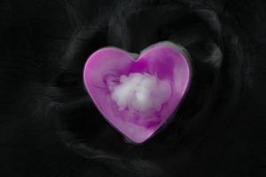 humo de hielo seco con copa en forma de corazón púrpura aislado sobre fondo negro foto