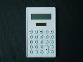 The white calculator on black background for business content. photo