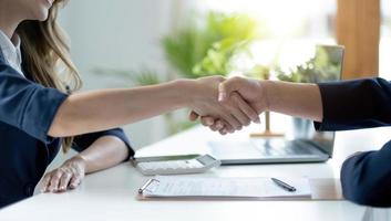 Man and woman are shaking hands in office. Collaborative teamwork. photo