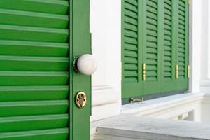 perilla blanca en la puerta y ventana de madera verde foto