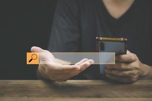 The concept of using technology to search for information, a man's hand is using a smartphone to search for information on social media via the Internet online. photo