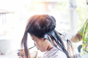 Hairdresser applies a hair mask to the woman in the beauty salon. Botox and keratin hair straightening procedure. photo