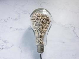 light bulb and alphabet wood cube on white marble for idea or think concept photo