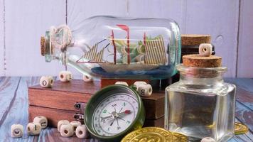 boat in  bottle on wood table for travel or transport concept photo