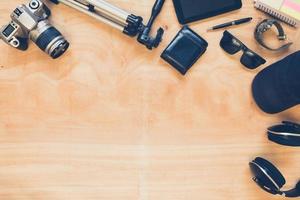 Top view of clothing and diverse personal accessory on the wooden table background. photo