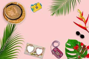 accessories composition for summer concept with tropical palm leaves on pastel pink background, top view and copy space photo