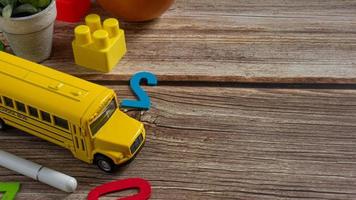 autobús escolar en mesa de madera para educación o concepto de regreso a la escuela foto