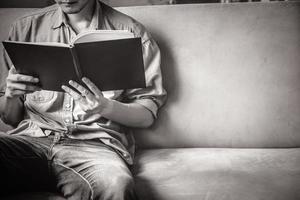 joven casual leyendo documentos en el sofá en casa. foto