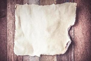 Top view of Burned old blank paper on wooden table background. photo