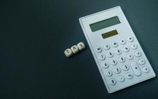 The wood text and calculator on black background for business content photo