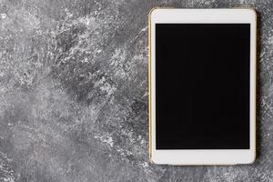White tablet touch computer gadget with touch blank black screen on grunge background. photo