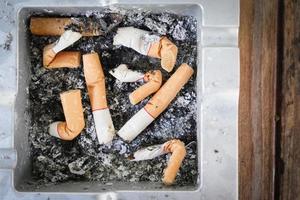 colillas de cigarrillos fumados en el cenicero foto