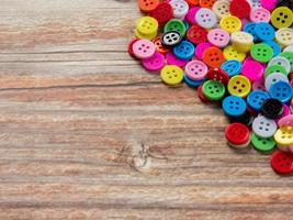 Buttons multi color on wood table for diy or handcrafted  concept. photo