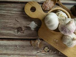 The garlic on wood table for food or cooking concept. photo
