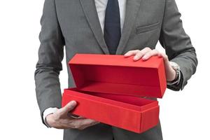 empresario sosteniendo una caja de regalo roja aislada sobre fondo blanco. foto