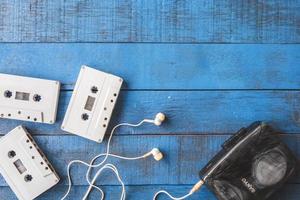 vista superior del reproductor de cassette con cinta de audio sobre fondo de mesa de madera azul, espacio libre para texto foto