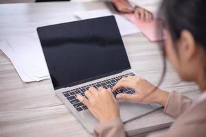 Concentrated multiethnic coworker busy using laptop brainstorm sharing thoughts at office meeting photo