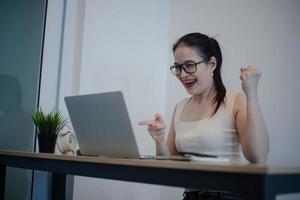 feliz emocionada mujer exitosa trabajando con su computadora portátil. foto