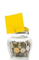 Coins in glass bottle with blank paper for text on white background, future saving concept photo