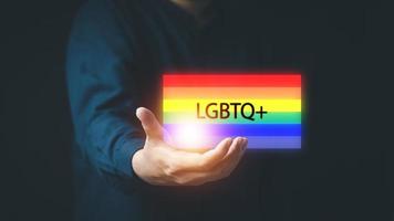 The concept of LGBTI people or LGBTQ queer men's hands with rainbow flags and messages photo