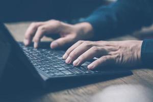 The concept of using technology to search for information, a man's hand is using a computer to search for information on social media via the Internet online. photo