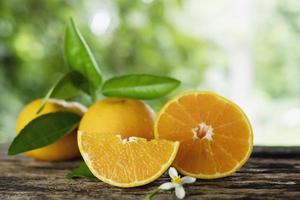 fruta naranja fresca y jugosa puesta en una vieja tabla de textura de madera - fruta naranja tropical para uso de fondo foto