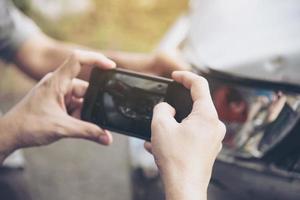 agente de seguros que trabaja durante el proceso de reclamación de accidentes de coche en el lugar - concepto de reclamación de seguros de personas y coches foto