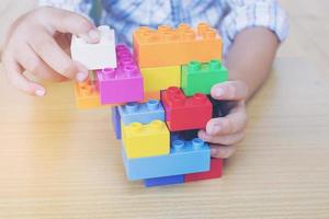 un niño jugando piezas de bloques de construcción creativos de plástico foto