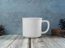 taza blanca sobre madera de mesa para maqueta o fondo foto