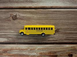 The school bus on wood table for education or back to school concept photo