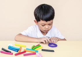 un niño está jugando arcilla de colores foto