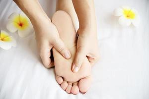 Woman receiving foot massage service from masseuse close up at hand and foot - relax in foot massage therapy service concept photo