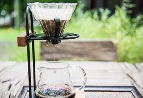 hacer café por goteo en una cafetería antigua con un jardín verde de fondo natural - café recién hecho en el concepto de naturaleza foto