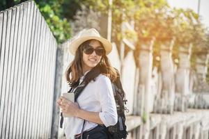 mujer joven viajera con mochila en una ciudad pequeña - concepto de actividad de viajero asiático al aire libre foto