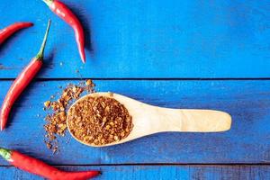 Top view of Red hot chilli peppers with cayenne on blue wooden table background, Free space for text photo
