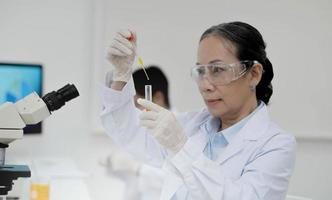 Health care researchers working in life science laboratory. Young female research scientist and senior male supervisor preparing and analyzing microscope slides in research lab. photo