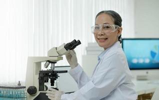 Research Laboratory Portrait of a Professor female scientist using a microscope smiling charmingly on camera Advanced scientific laboratory for medicine biotechnology microbiological development photo